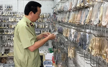 Cán bộ quản lý thị trường Hà Nội kiểm tra cơ sở kinh doanh tại chợ Ninh Hiệp, Gia Lâm. Ảnh: QUYÊN LƯU