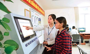 Cán bộ UBND quận Long Biên hướng dẫn người dân tra cứu thông tin quy hoạch tại Bộ phận một cửa. Ảnh: NHẬT NAM 