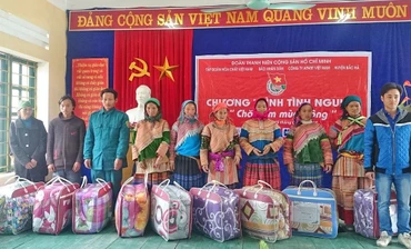 Đại diện các hộ gia đình chính sách xã Lùng Phình, huyện Bắc Hà (Lào Cai) nhận quà do Đoàn Thanh niên Báo Nhân Dân trao tặng. Ảnh: HOÀNG CHIẾN