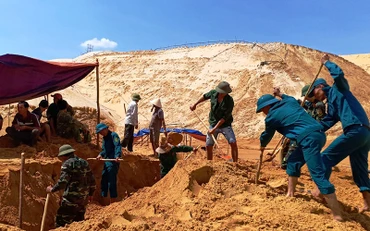 Lực lượng cứu hộ đào cát tìm kiếm nạn nhân mất tích.