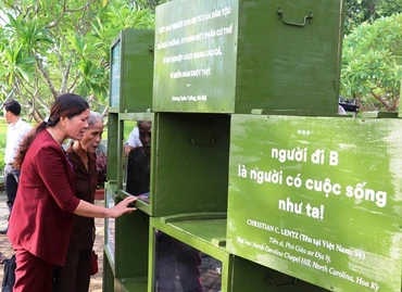 Khách du lịch xem kỷ vật đi B tại triển lãm.