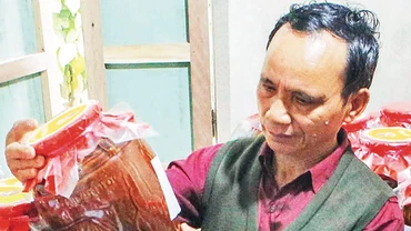 Già làng Lê Văn Nghĩa bên sản phẩm tâm huyết. Ảnh: TRẦN LÊ LÂM
