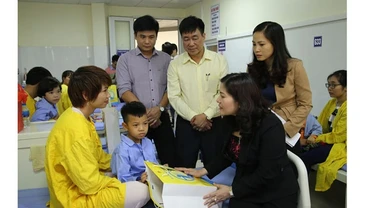 Đại diện Bộ Lao động - Thương binh và Xã hội tặng quà cho trẻ phẫu thuật tại Bệnh viện Răng - Hàm - Mặt Trung ương (Ảnh: NFVC).