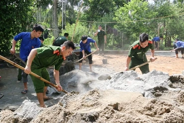 Thanh niên tình nguyện trộn hồ làm sân, cứng hóa ngõ vào nhà ở của gia đình có công.