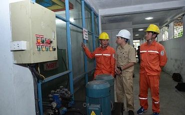 Công nhân Tổng công ty Điện lực miền bắc hướng dẫn doanh nghiệp sử dụng điện tiết kiệm. Ảnh: KIM NGÂN 