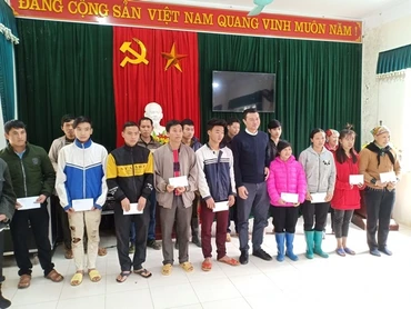 Đại diện Báo Nhân Dân trao quà cho các hộ nghèo.