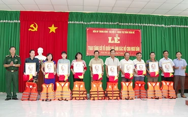 Lãnh đạo địa phương và BĐBP Sóc Trăng trao tặng cờ Tổ quốc, ảnh Bác Hồ và áo phao cho bà con ngư dân.
