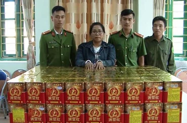 Đối tượng Lan (nữ đeo kính) và tang vật tại cơ quan Công an huyện Bát Xát (Lào Cai).