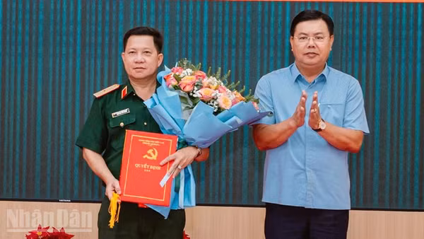 Đồng chí Nguyễn Tiến Hải, Ủy viên Trung ương Đảng, Bí thư Tỉnh ủy, Bí thư Đảng ủy Quân sự tỉnh An Giang trao quyết định, tặng hoa chúc mừng Thiếu tướng Nguyễn Văn Hùng. 