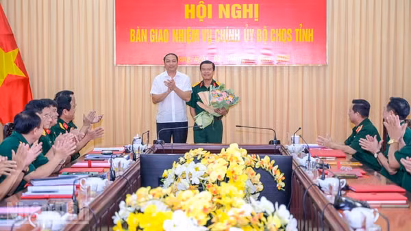 Đồng chí Lâm Minh Thành, Phó Bí thư Thường trực Tỉnh ủy An Giang trao hoa chúc mừng Đại tá Nguyễn Việt Thắng, Phó Bí thư Thường trực Đảng ủy Quân sự, Chính ủy Bộ Chỉ huy quân sự tỉnh An Giang. (Ảnh: PHƯƠNG VŨ)
