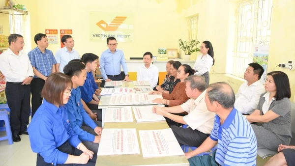 Tổng Biên tập Lê Quốc Minh trao đổi với người dân về dự thảo các văn kiện trình Đại hội XIV do Báo Nhân Dân trưng bày tại Bưu điện Văn hóa xã Tân Hưng, tỉnh Hưng Yên. (Ảnh THẾ ĐẠI)