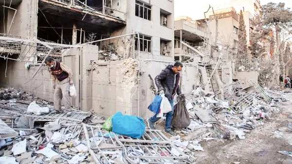 Người dân thu dọn đống đổ nát sau một vụ không kích tại Iran. (Ảnh: THE NEW YORK TIMES)