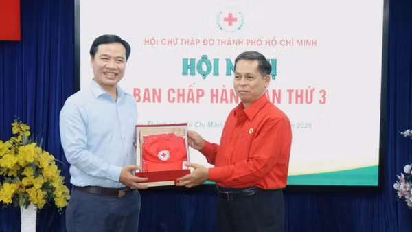 Ông Nguyễn Minh Nhựt nhận quà lưu niệm từ Hội Chữ thập đỏ thành phố.