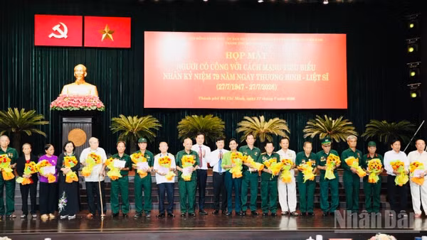 Đại diện lãnh đạo thành phố tặng quà cho người có công tiêu biểu của thành phố tại buổi họp mặt.