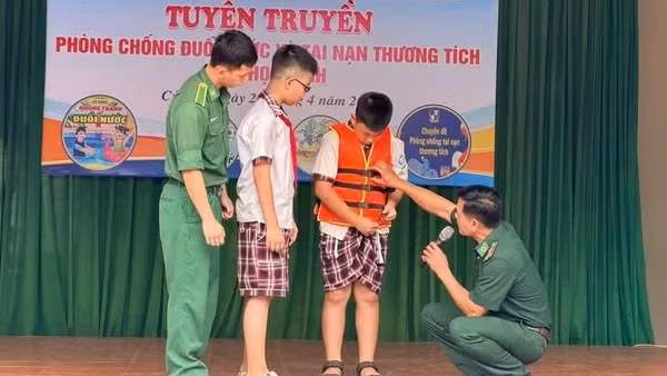 Các cán bộ, chiến sĩ Đồn Biên phòng cửa khẩu cảng Cửa Lò-Bến Thủy hướng dẫn các em học sinh sử dụng áo phao đúng cách.