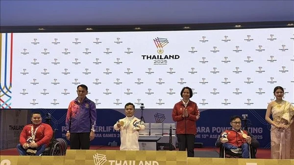 Trưởng đoàn Lê Thị Hoàng Yến chụp ảnh lưu niệm với vận động viên Huy chương Bạc Nguyễn Bình An và Huy chương Đồng Huỳnh Ngọc Phụng. (Ảnh: TTXVN)