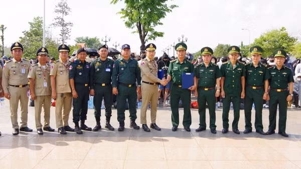 Lực lượng chức năng Campuchia và Đồn biên phòng cửa khẩu quốc tế Hoa Lư ký biên bản bàn giao công dân Việt Nam tại cột mốc 69. (Ảnh: TTXVN)