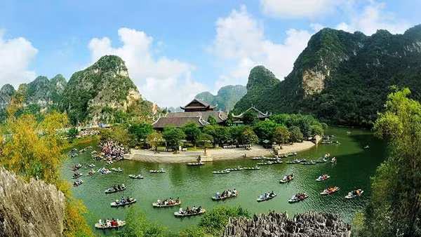 Du khách tham quan Di sản Văn hóa và Thiên nhiên thế giới Tràng An. (Ảnh: NINH MẠNH THẮNG)