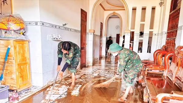 Chiến sĩ Trung đoàn bộ binh 812 giúp đồng bào Chăm ở thôn Lâm Giang (xã Hàm Thuận Bắc) dọn bùn.