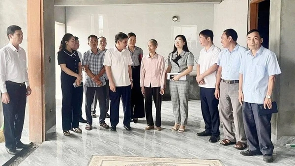 Ban Chỉ đạo xóa nhà tạm, nhà dột nát huyện Lâm Thao chia sẻ niềm vui với gia đình bà Nguyễn Thị Hữu (áo hồng đứng giữa) ở khu 5, xã Tứ Xã bên căn nhà mới.