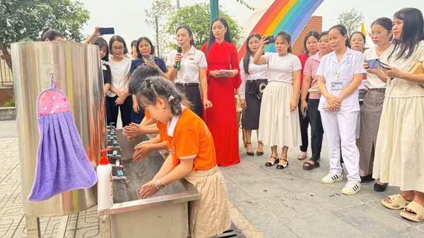 Cán bộ Trạm Y tế phường Tây Tựu hướng dẫn các em học sinh trên địa bàn rửa tay bằng xà phòng đúng cách để phòng bệnh tay chân miệng.