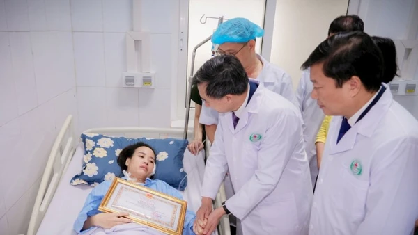 Thứ trưởng Y tế Trần Văn Thuấn trao Bằng khen của Bộ trưởng Y tế cho điều dưỡng Nguyễn Thị Thùy Trang.