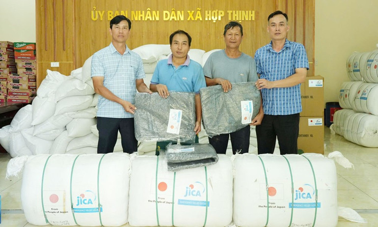 Lãnh đạo UBND xã Hợp Thịnh trao quà của nhà tài trợ đến người dân. (Ảnh: MAI TOAN) 5.jpg