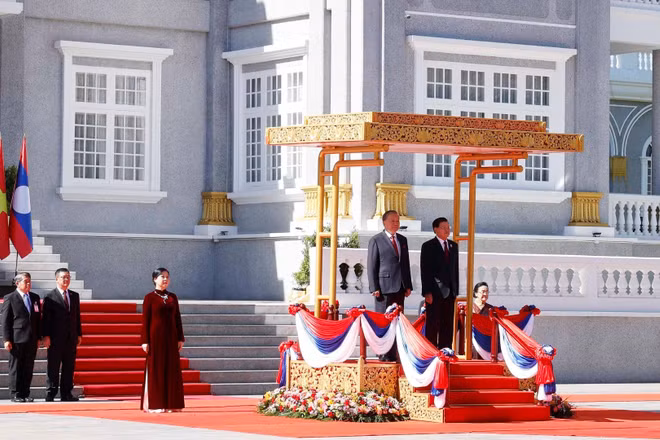Tổng Bí thư Tô Lâm và Tổng Bí thư, Chủ tịch nước Lào Thongloun Sisoulith trên bục danh dự, nghe Quân nhạc cử Quốc thiều hai nước. (Ảnh: Thống Nhất/TTXVN)