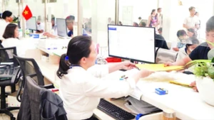 Người dân làm thủ tục hành chính tại Ủy ban nhân dân quận Bình Tân trước thời điểm thực hiện mô hình chính quyền địa phương hai cấp. (Ảnh THẾ ANH)