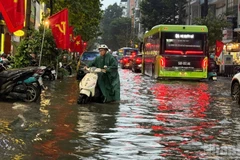 Mưa lớn cùng lúc với triều cường dâng cao nhiều khu vực ở Thành phố Hồ Chí Minh khiến người dân di chuyển khó khăn.