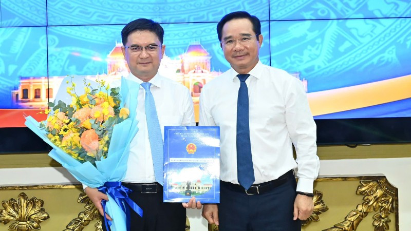 Chủ tịch Ủy ban nhân dân Thành phố Hồ Chí Minh Nguyễn Văn Được trao quyết định, tặng hoa chúc mừng đồng chí Nguyễn Mạnh Cường. (Ảnh: VIỆT DŨNG)