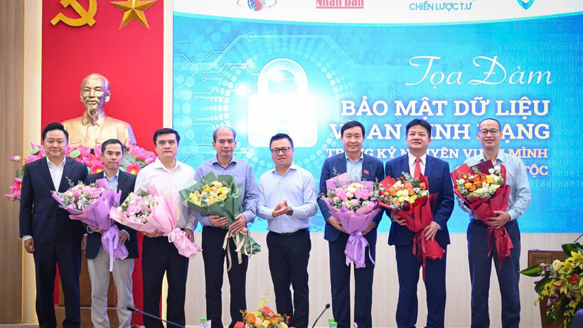 Tổng Biên tập Báo Nhân Dân Lê Quốc Minh và Phó Tổng Biên tập Báo Nhân Dân Phan Văn Hùng tặng hoa các diễn giả của buổi tọa đàm về bảo mật dữ liệu và an ninh mạng. (Ảnh: THÀNH ĐẠT)