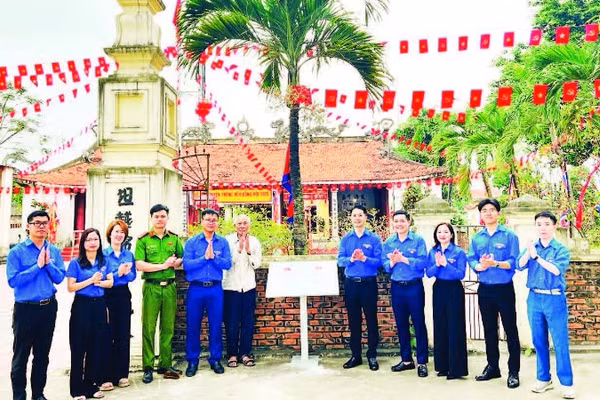 Đoàn viên thanh niên tổ chức gắn biển số hóa di tích tại Đình Đông Hội (Ảnh NINH BÌNH)