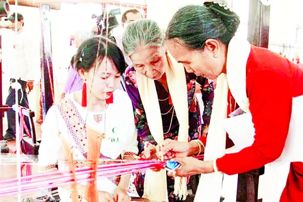 Nghệ nhân Đạt Thị Nam (áo cam) truyền dạy kỹ thuật dệt hoa văn Chăm cổ cho phụ nữ Chăm.