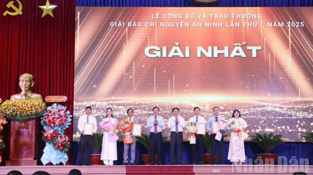 Bí thư Tỉnh ủy Long An Nguyễn Văn Quyết (trái) và Chủ tịch UBND tỉnh Long An (phải) trao chứng nhận và hoa cho các tác giả đạt giải Nhất giải báo chí Nguyễn An Ninh 2025. long-an-6new-115.jpg