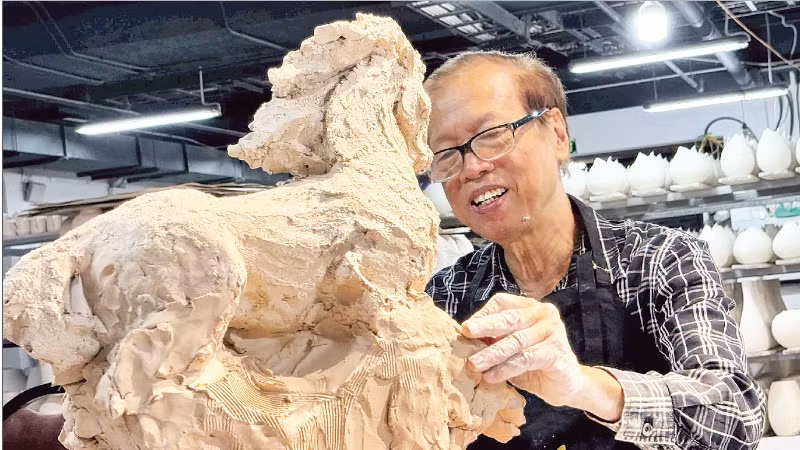 Nhà điêu khắc Nguyễn Kim Xuân bên một tác phẩm dành cho năm Bính Ngọ 2026.