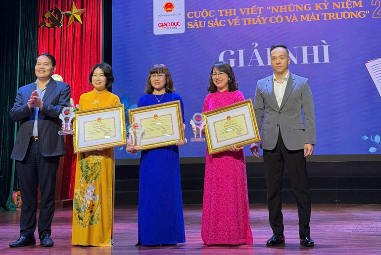 Ông Phạm Tiến Toàn, Phó Chánh Văn phòng Bộ Giáo dục và Đào tạo cùng ông Nguyễn Văn Thanh, Phó Vụ trưởng Học sinh, Sinh viên (Bộ Giáo dục và Đào tạo) trao giải Nhì cho các tác giả.