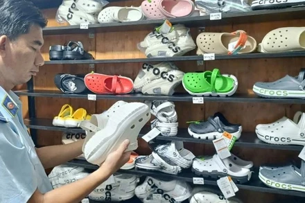 Lực lượng Quản lý thị trường Thành phố Hồ Chí Minh kiểm tra dép có dấu hiệu giả mạo nhãn hiệu tại một hộ kinh doanh.