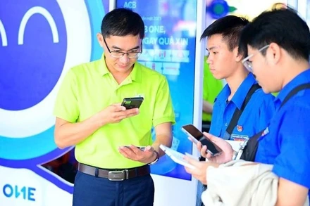 Nhân viên Ngân hàng ACB giới thiệu với khách hàng các tiện ích thanh toán số. (Ảnh ACB)