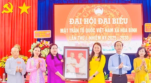 Đồng chí Hồ Thanh Thủy, Phó Bí thư Tỉnh ủy Cà Mau, trao tặng ảnh Bác Hồ và Bác Tôn, chúc mừng Đại hội Ủy ban Mặt trận Tổ quốc Việt Nam xã Hòa Bình. 