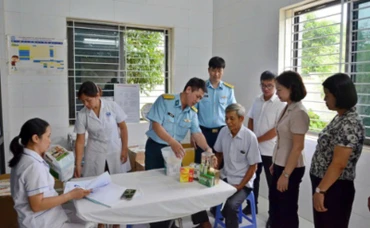 Đại diện lãnh đạo phường Tùng Thiện và Học viện Phòng không-Không quân khám bệnh, cấp thuốc miễn phí cho người có công. 