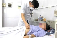 Bác sĩ Lê Văn Thiệu khám cho người bệnh. 