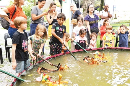 Du khách quốc tế “nhí” thử điều khiển rối nước trong một buổi biểu diễn do Đông Đô tổ chức. (Ảnh: NVCC)