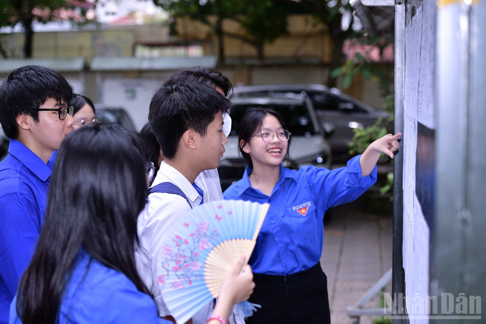 Tình nguyện viên hỗ trợ các thí sinh tại điểm thi Trường trung học phổ thông Nguyễn Gia Thiều (quận Long Biên, thành phố Hà Nội). ndo_br_miu-0896.jpg