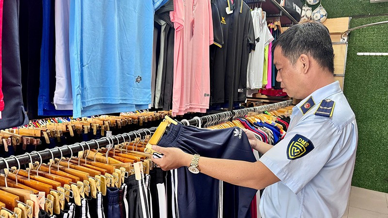 Lực lượng quản lý thị trường thành phố kiểm tra một điểm kinh doanh sản phẩm thời trang vi phạm. (Ảnh CTV).