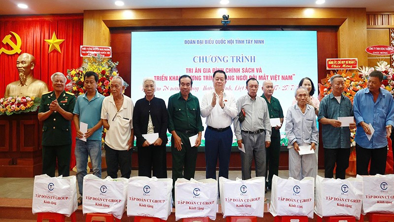 Đồng chí Nguyễn Trọng Nghĩa trao quà và hoa tri ân các gia đình chính sách.