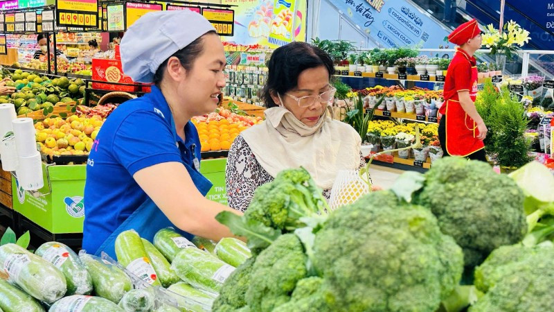 Người dân mua rau xanh bình ổn thị trường trong một siêu thị Co.opmart ở Thành phố.