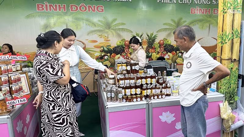Người dân và khách tham quan tìm mua đặc sản tại một gian hàng của tỉnh Đồng Tháp trong phiên chợ.