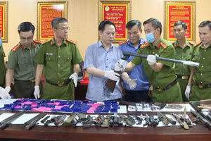 Công an xem xét vũ khí nóng thu hồi được.
