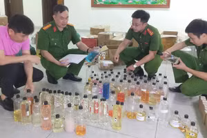 Công an xem xét các loại hương liệu mà các đối tượng đã sử dụng sản xuất nước hoa giả.